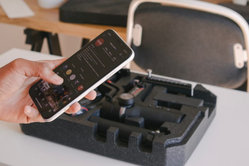 Person filming content creation of an unboxing video while looking on social